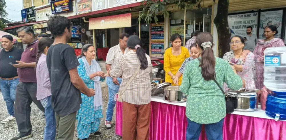देहरादून के मालिक चौक पर गुलाबी मेज़ से लोगों को भोजन देते सेवादार
